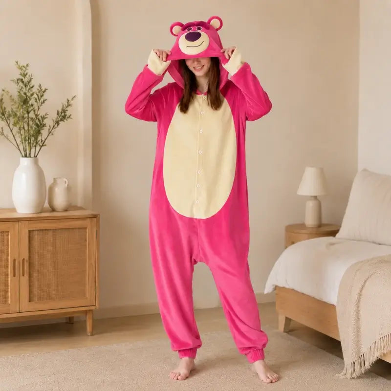 femme qui est dans une chambre en train de tenir le capuche de sa grenouillère avec une tete d'ours qui est rose