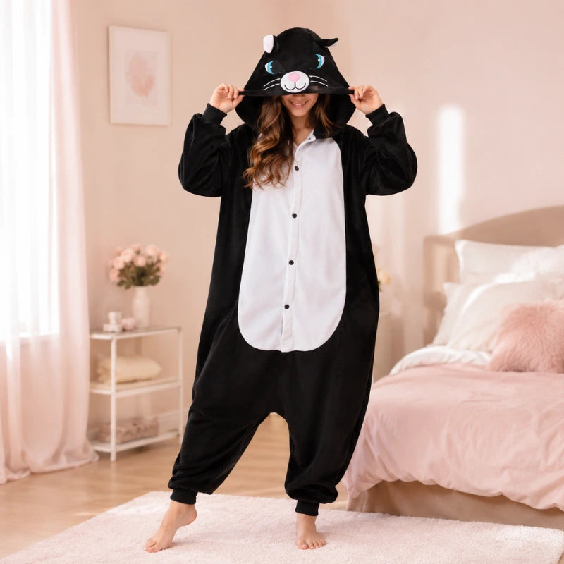 femme dans sa chambre qui porte une combinaison kigurumi noir et blanc en tenant sa capuche avec une tête de chat